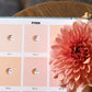 Color swatch card with pink shades and a pink flower on a wooden surface.